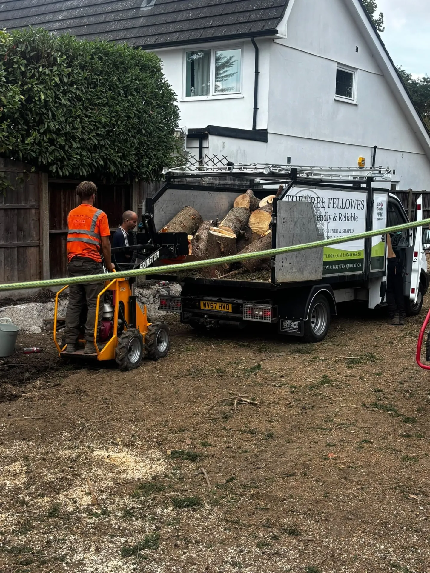 Tree surgeon loading cut timber into The Tree Fellowes tipper truck